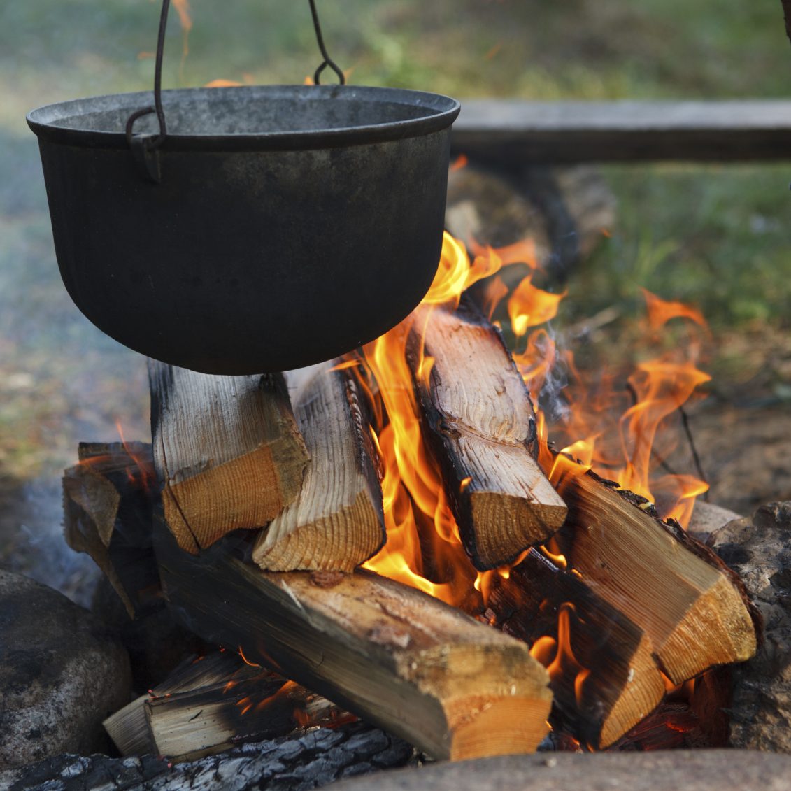 Preparing food on campfire in wild camping